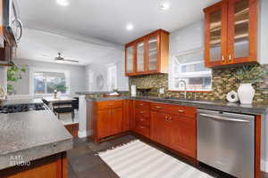 Kitchen with appliances with stainless steel finishes, tasteful backsplash, dark countertops, recessed lighting, and glass insert cabinets