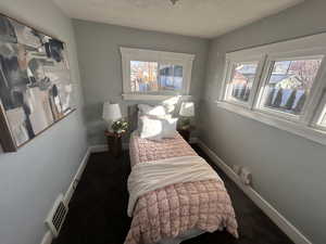 Bedroom featuring dark colored carpet