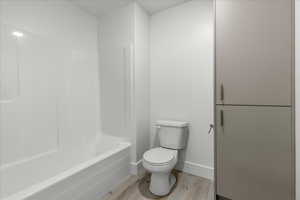 Bathroom featuring light wood finished floors and bathtub / shower combination