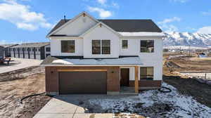 View of front of property with a mountain view, a garage, brick siding, and roof with shingles