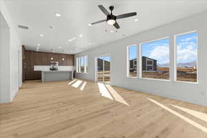 Unfurnished living room with light wood-type flooring, recessed lighting, a mountain view, and ceiling fan
