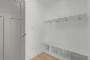 Mudroom with light wood-style flooring and baseboards