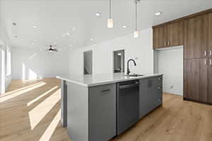 Kitchen with stainless steel dishwasher, a kitchen island with sink, open floor plan, light wood finished floors, and recessed lighting