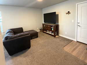 Living area featuring carpet and a textured ceiling
