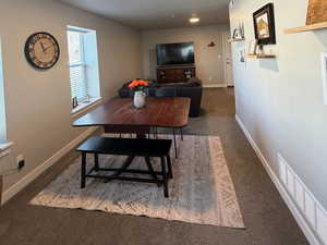 Dining area with carpet and a textured ceiling