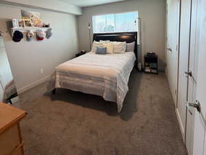 Bedroom with carpet, a textured ceiling, and two closets