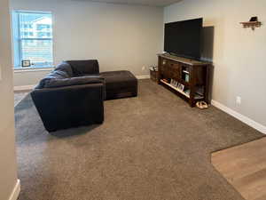 Carpeted living room with a textured ceiling and baseboards