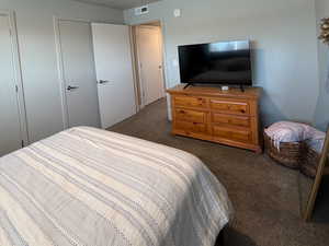 Bedroom with a textured ceiling and dark colored carpet
