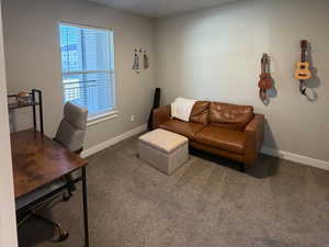 Carpeted living area with baseboards and an office area