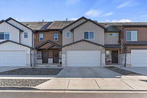 Craftsman inspired home with board and batten siding, driveway, stone siding, a garage, and covered porch