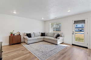 Living area featuring light wood finished floors, recessed lighting, and a textured ceiling