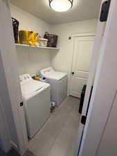 Washroom featuring a textured ceiling and washer and clothes dryer