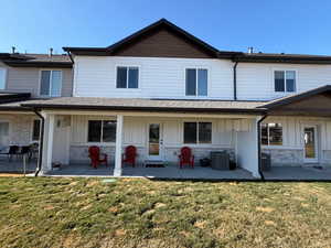 Rear view of property featuring stone siding, a yard, and board and batten siding