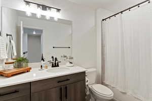 Bathroom featuring shower / bathtub combination with curtain and vanity