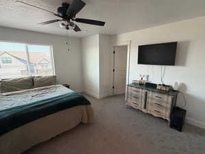 Bedroom featuring ceiling fan, carpet flooring, and a textured ceiling