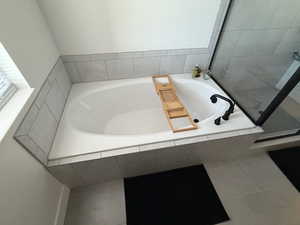 Full bath with a bath, a shower stall, and tile patterned floors