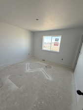 Spare room featuring baseboards and a textured ceiling