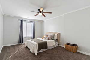 Bedroom with ornamental molding, a ceiling fan, and carpet flooring