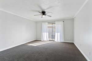 Carpeted spare room featuring crown molding and ceiling fan