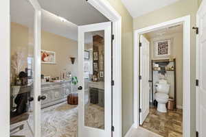 Bathroom featuring french doors and stone finish flooring
