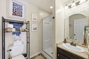 Full bath with a shower stall and vanity