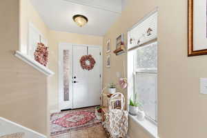 Tiled foyer with baseboards