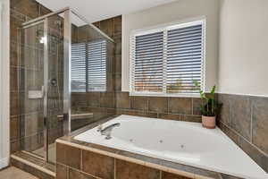 Bathroom with a whirlpool tub and a stall shower