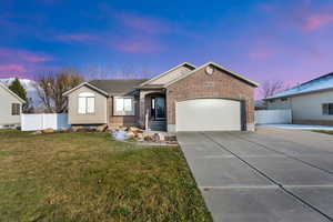 Single story home featuring concrete driveway, brick siding, and an attached garage