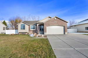 Single story home featuring brick siding, concrete driveway, and a garage