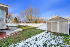 Fenced backyard featuring a storage shed, a patio area, and a mountain view