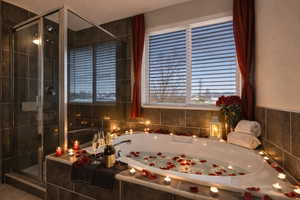 Bathroom featuring a jetted tub and a stall shower