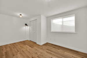 Unfurnished bedroom featuring a closet and light wood-style flooring