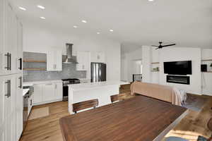 Dining room with light wood-style floors, ceiling fan, recessed lighting, and high vaulted ceiling