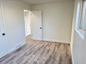 Unfurnished bedroom featuring light wood-style flooring and baseboards