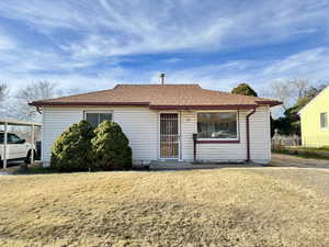 View of front of home featuring a shingled roof and a front yard