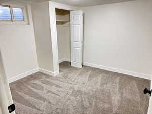 Unfurnished bedroom featuring a closet and light carpet