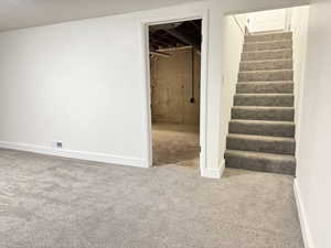 Finished basement featuring carpet and stairs