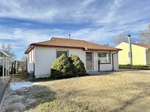 View of front of home with roof with shingles and a front lawn