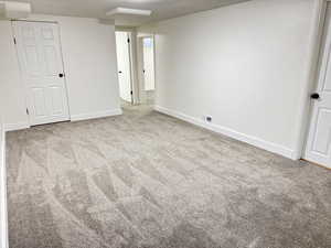 Unfurnished bedroom with light colored carpet and baseboards