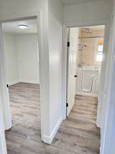 Hall with light wood-style flooring and baseboards