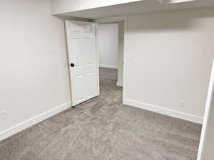 Spare room with baseboards and carpet