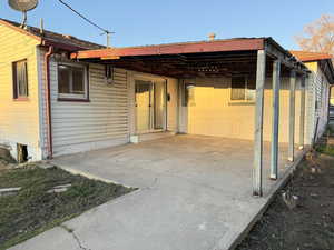 Back of house with a carport and a patio
