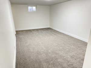 Basement with light carpet and baseboards