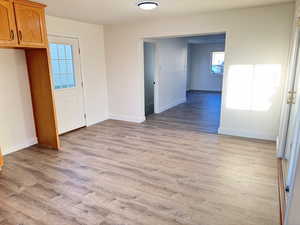 Unfurnished dining area with light wood finished floors and baseboards