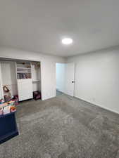 Unfurnished bedroom featuring a closet and carpet floors