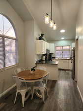 Dining space with lofted ceiling, dark wood finished floors, and recessed lighting