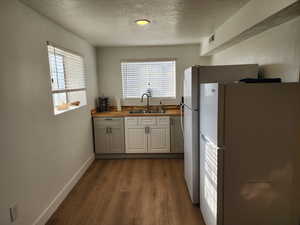 Kitchen featuring freestanding refrigerator, a textured ceiling, wooden counters, and dark wood-style flooring