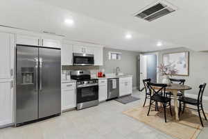 Kitchen featuring stainless steel appliances, white cabinets, and recessed lighting