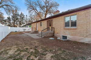 Back of property with brick siding, a chimney, and a fenced backyard