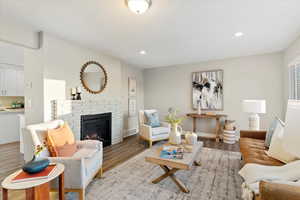 Living room with a fireplace, recessed lighting, and wood finished floors